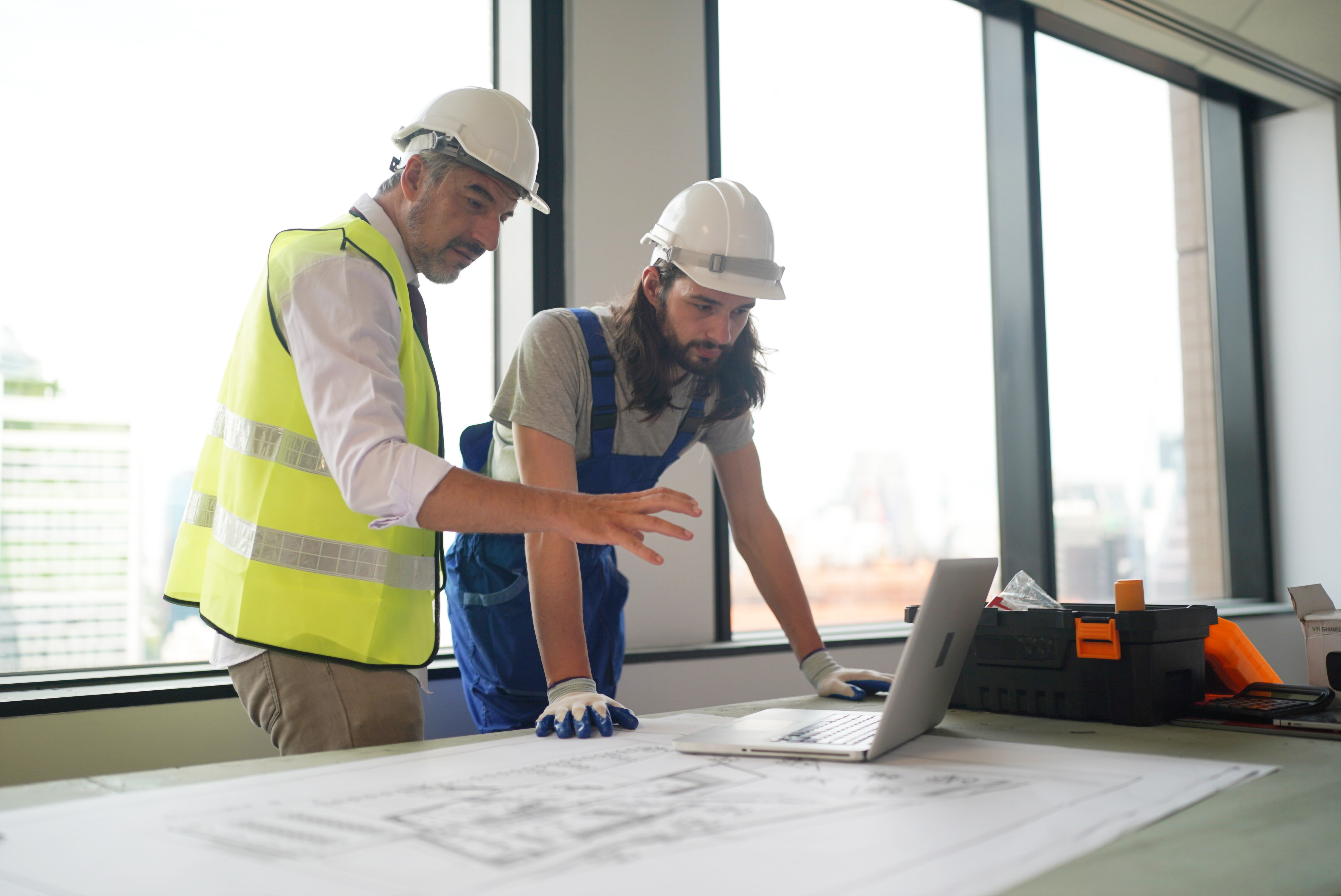 construction workers looking at laptop