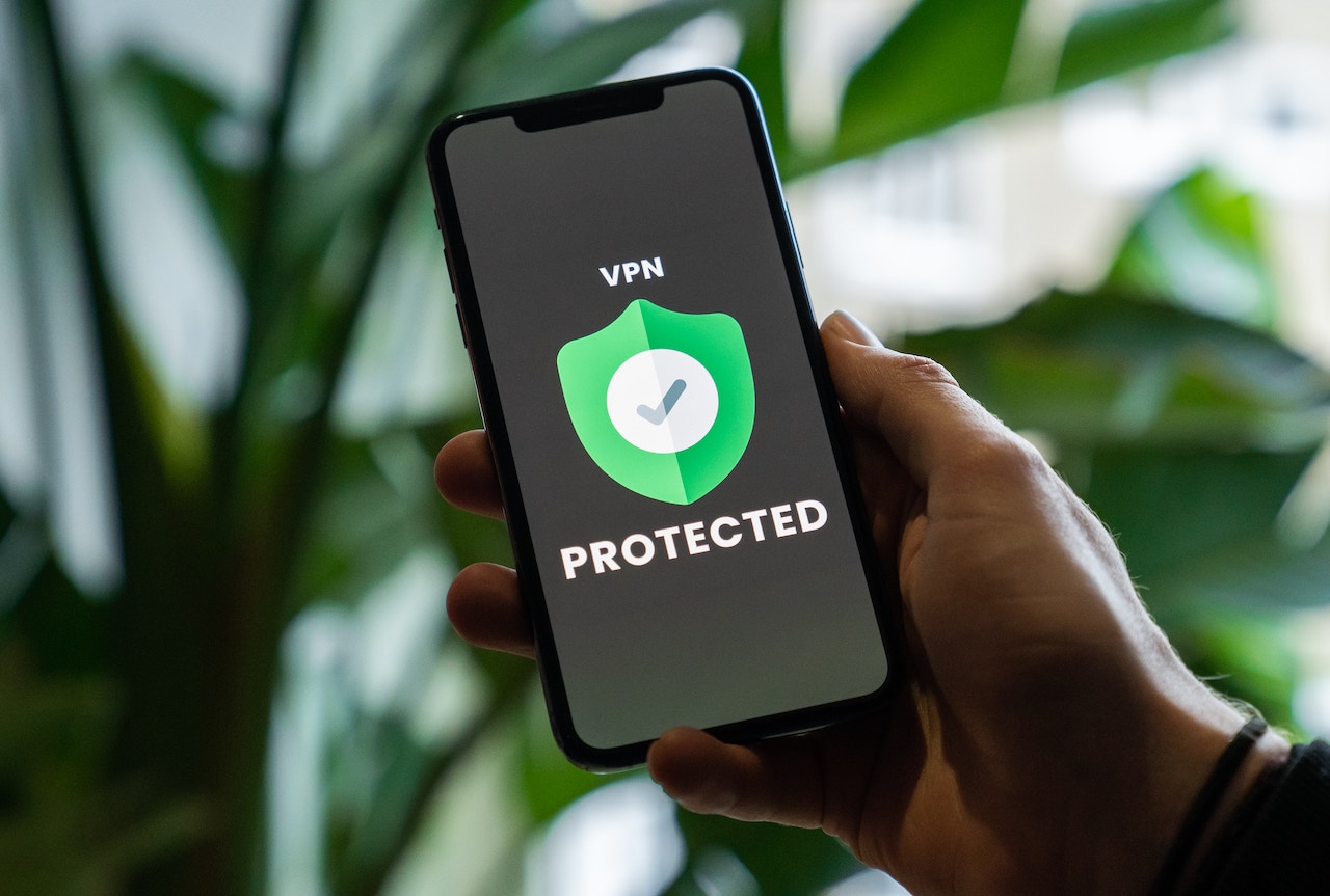 Person holding phone that shows a VPN security risks screen with the words "protected"